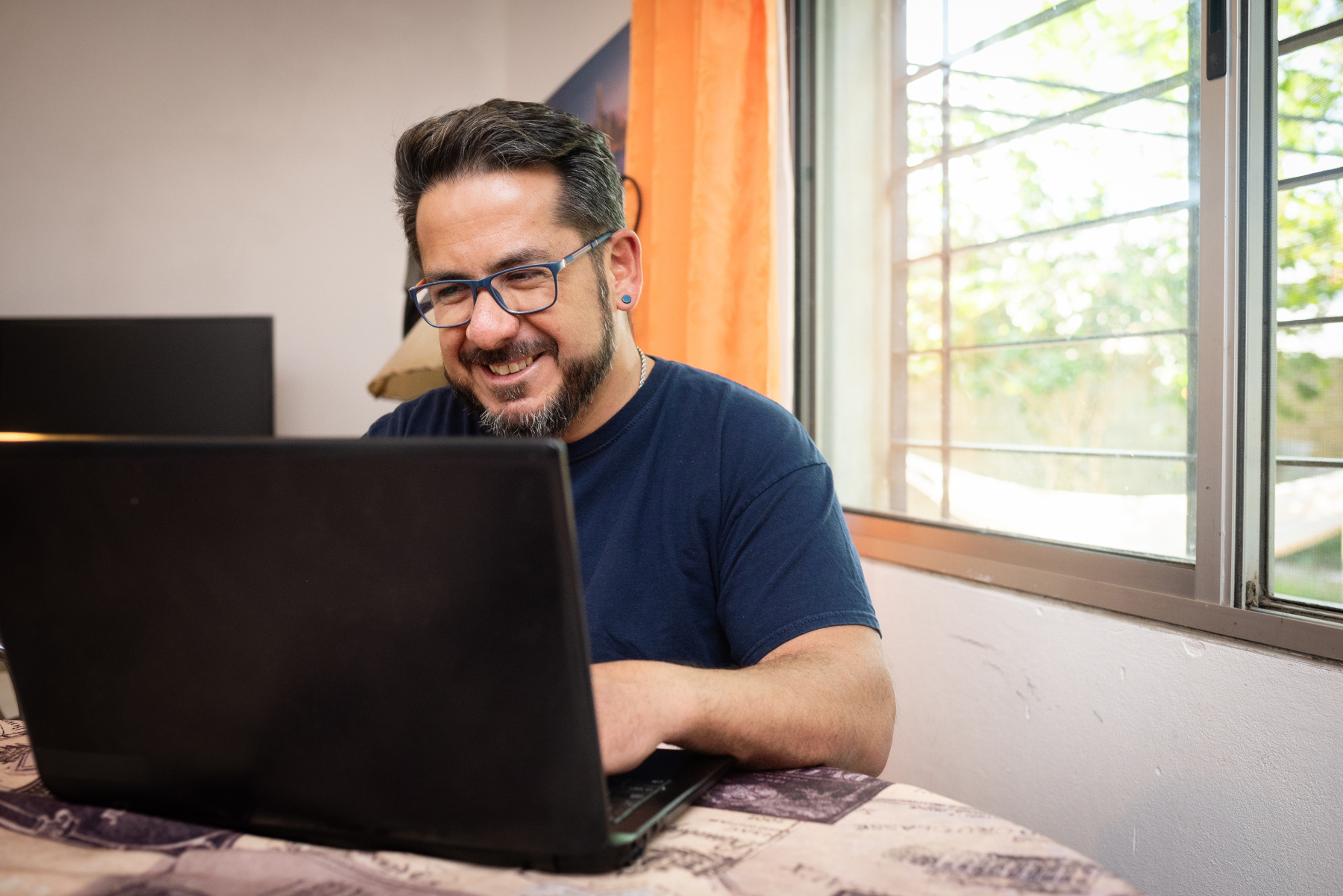 Smiling man at his desk working on a computer